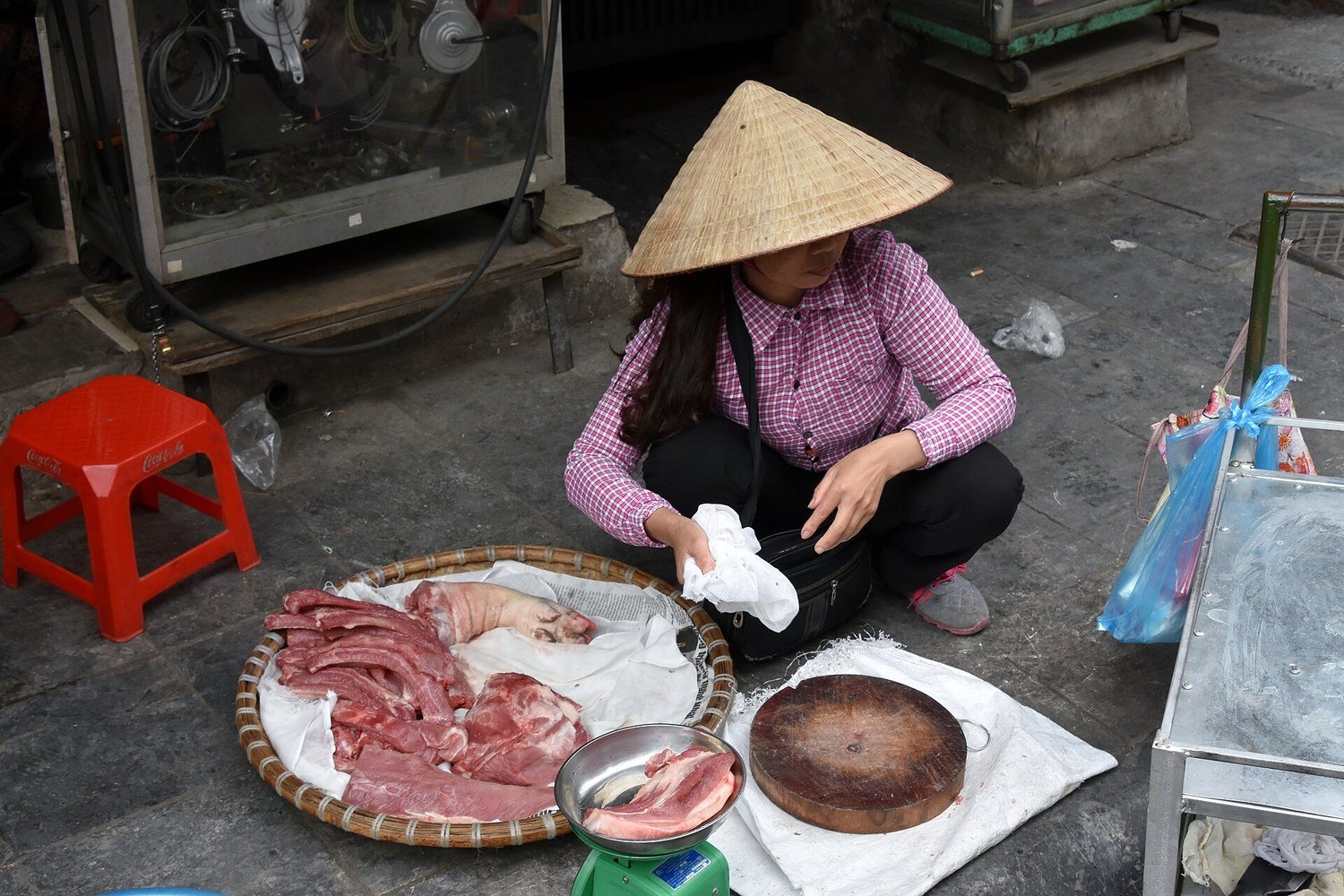 河內老城區街邊一位戴斗笠的越南婦女在路邊賣肉