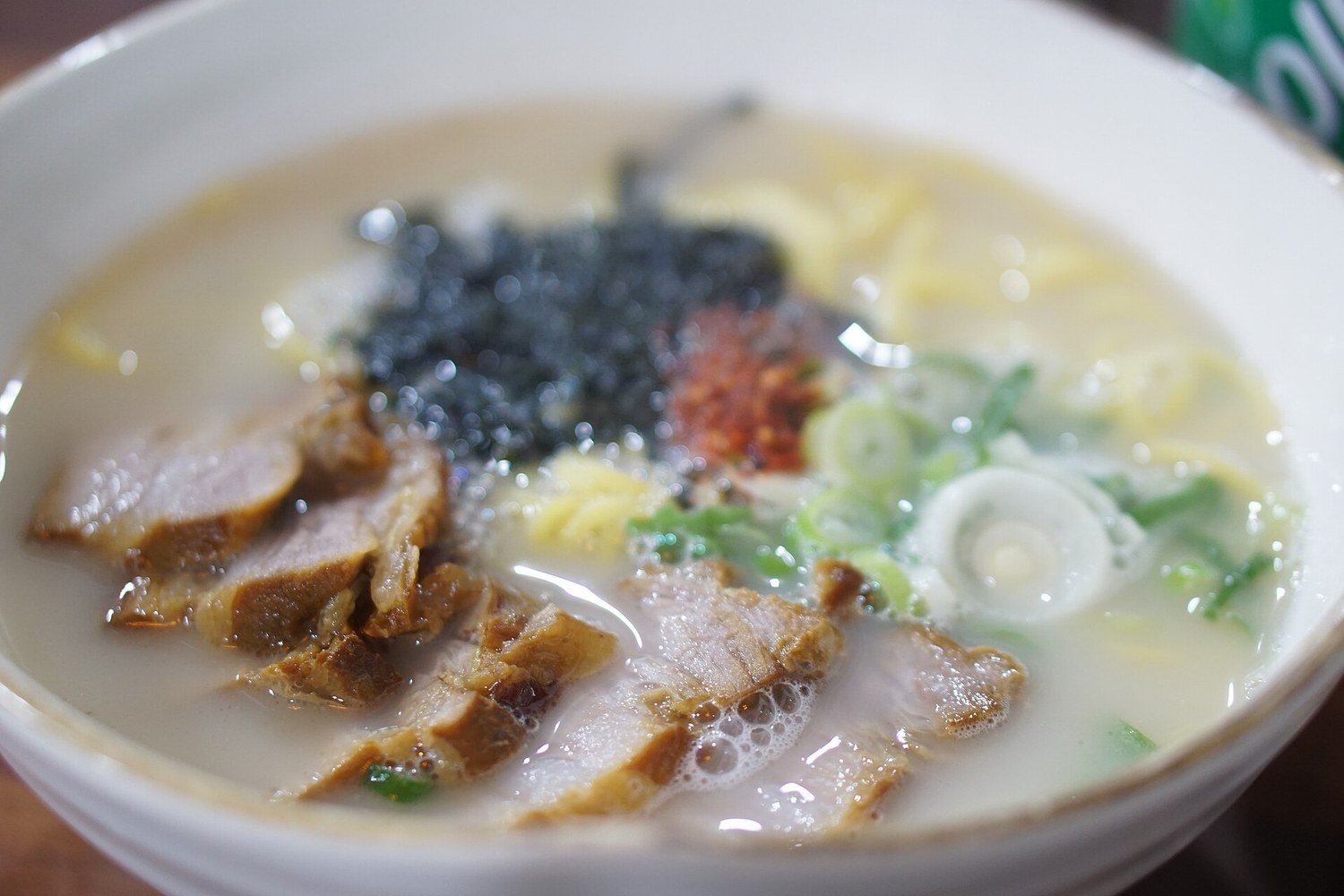 一碗濟州島肉麵，白色湯頭上鋪著豬肉片
